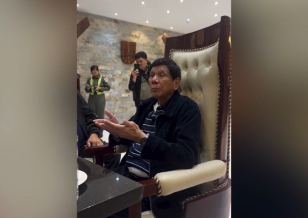 Former Philippine President Rodrigo Duterte questions ICC arrest warrant while seated in a high-backed chair.