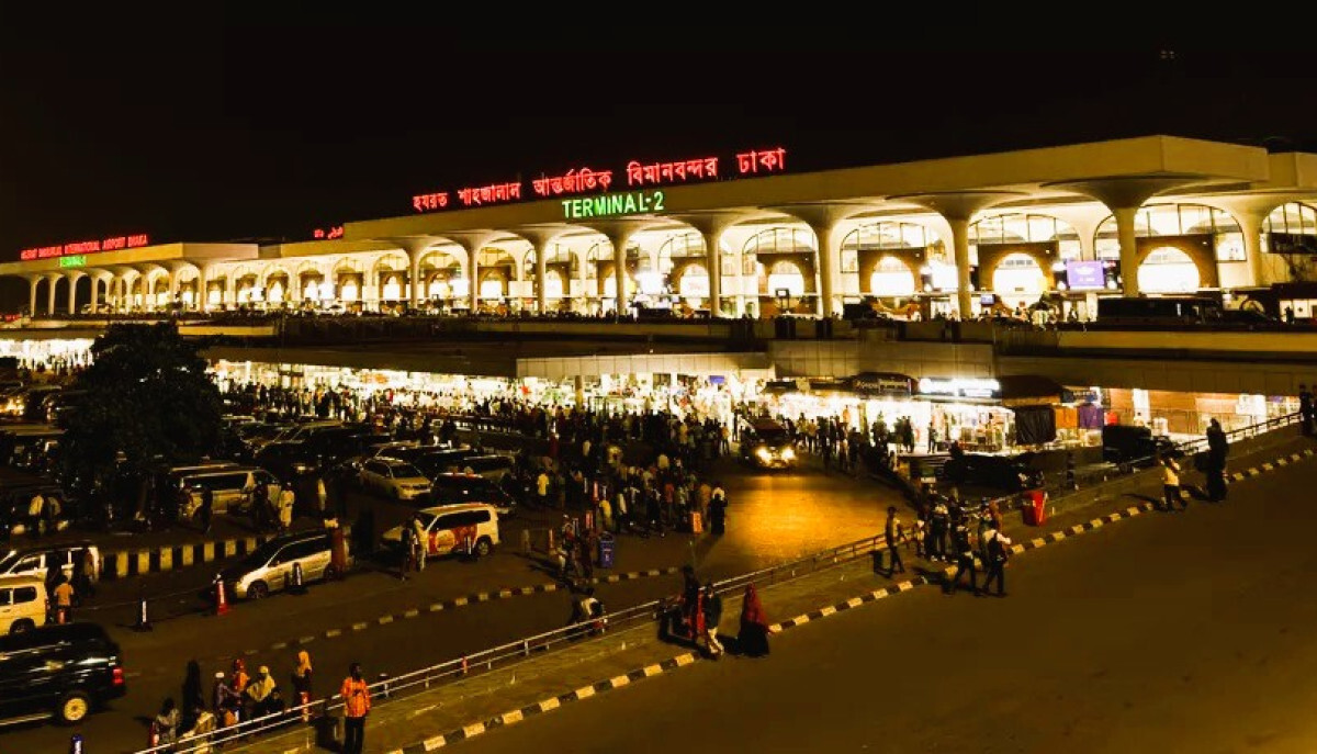 Hazrat Shahjalal International Airport in Dhaka at night, crowded with passengers and vehicles.