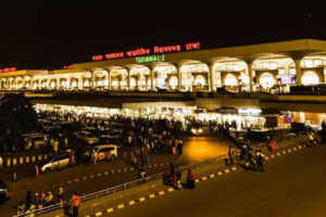 Hazrat Shahjalal International Airport in Dhaka at night, crowded with passengers and vehicles.