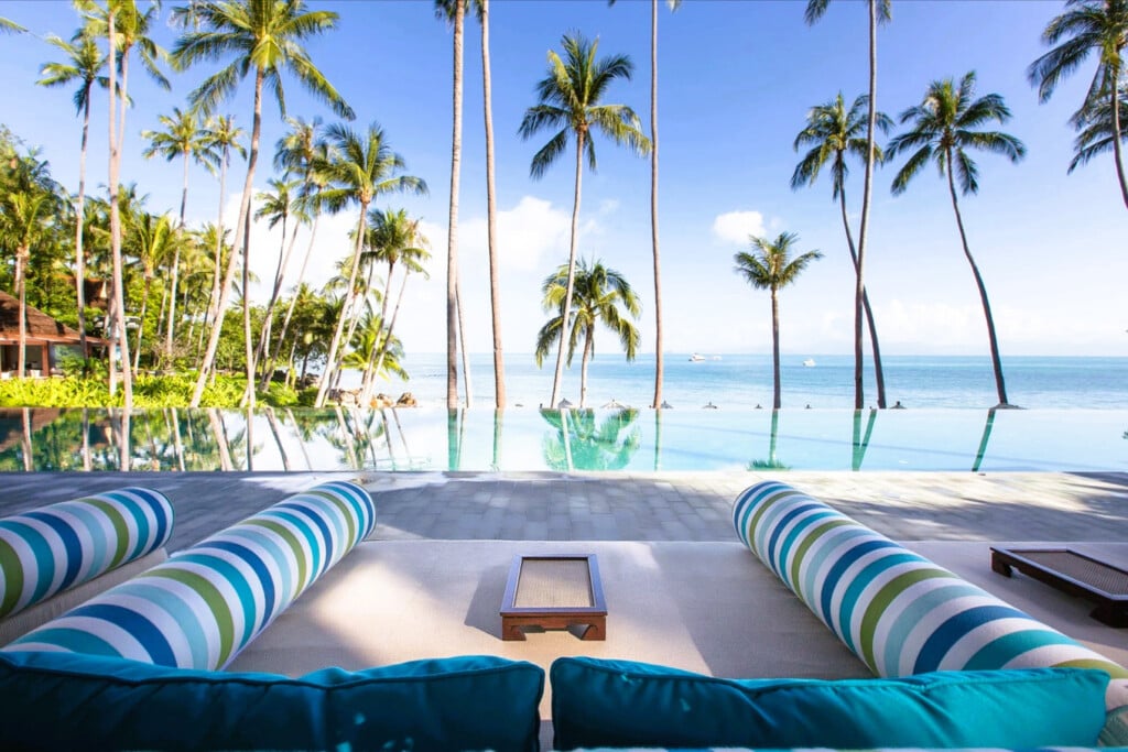 Luxury beachfront infinity pool with palm trees at Four Seasons Resort Koh Samui, Thailand